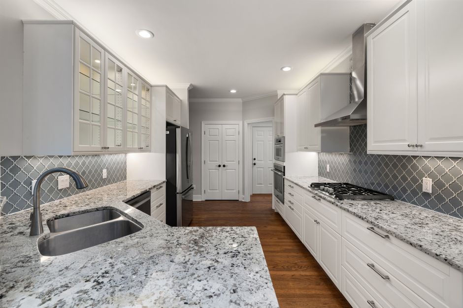 Bright modern kitchen featuring elegant granite countertops and stainless steel appliances.
